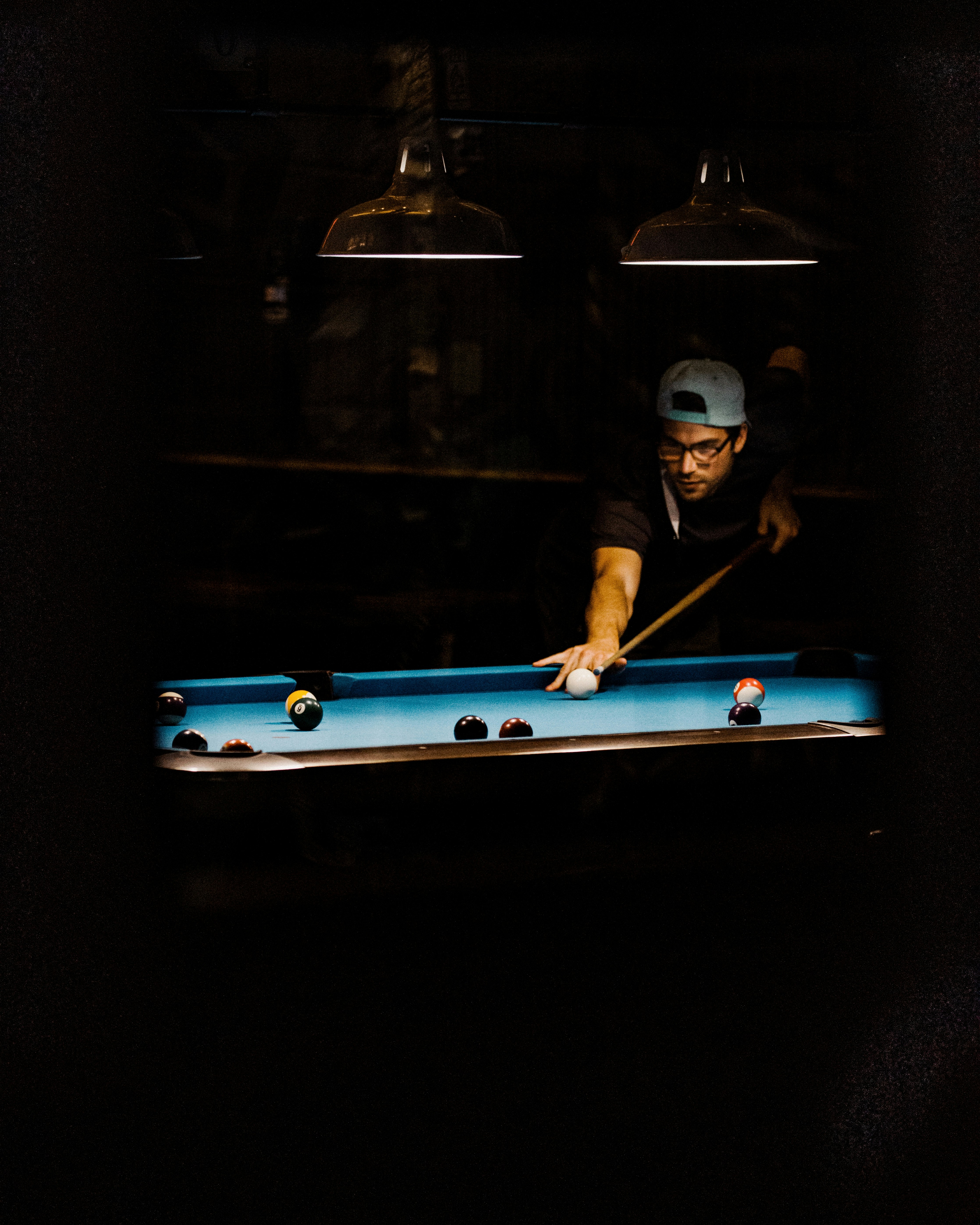 man in black t-shirt playing billiard